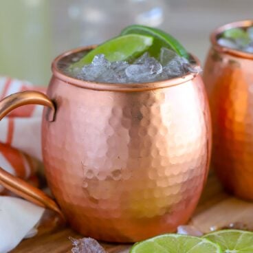 Moscow Mule in a copper mug garnished with lime two lime wedges.