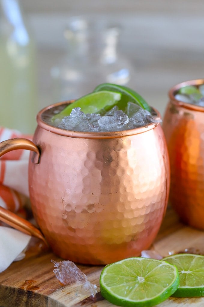 Moscow Mule in a copper mug garnished with lime two lime wedges.