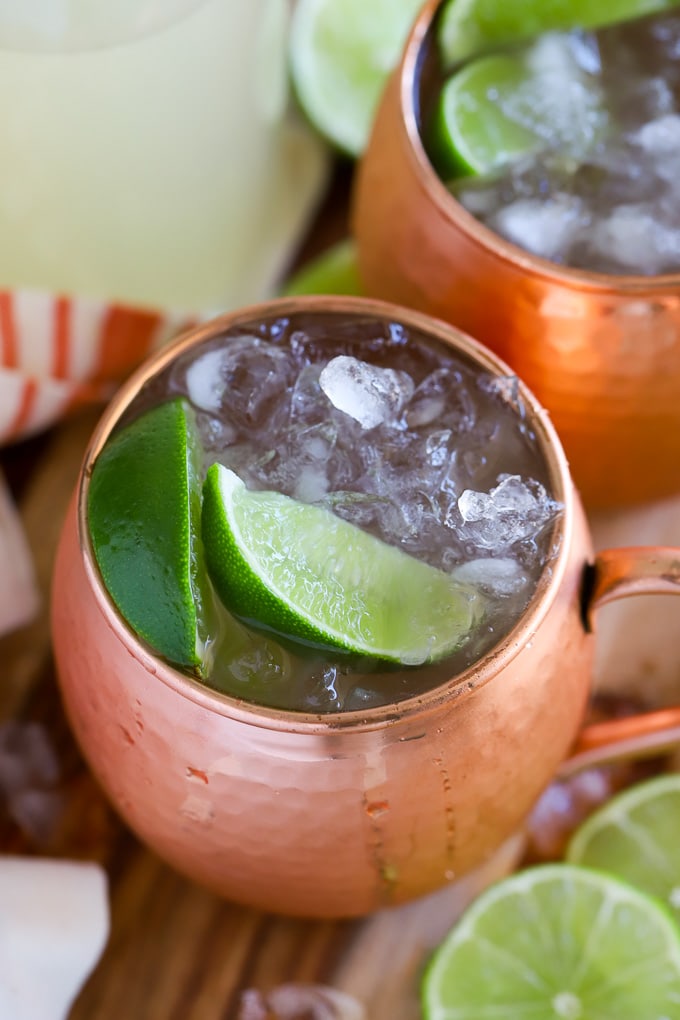 Moscow Mule in a copper mug garnished with lime two lime wedges.