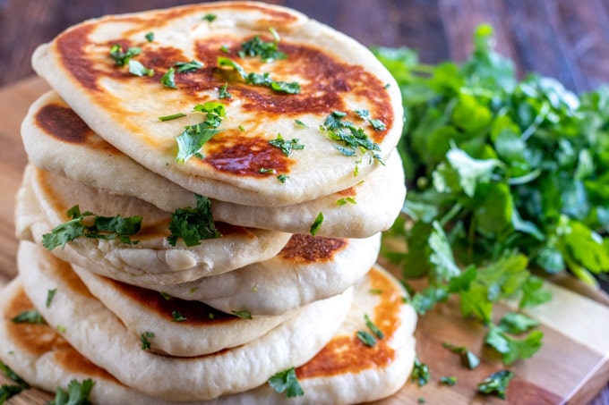 stacked pieces of Naan on a cutting board