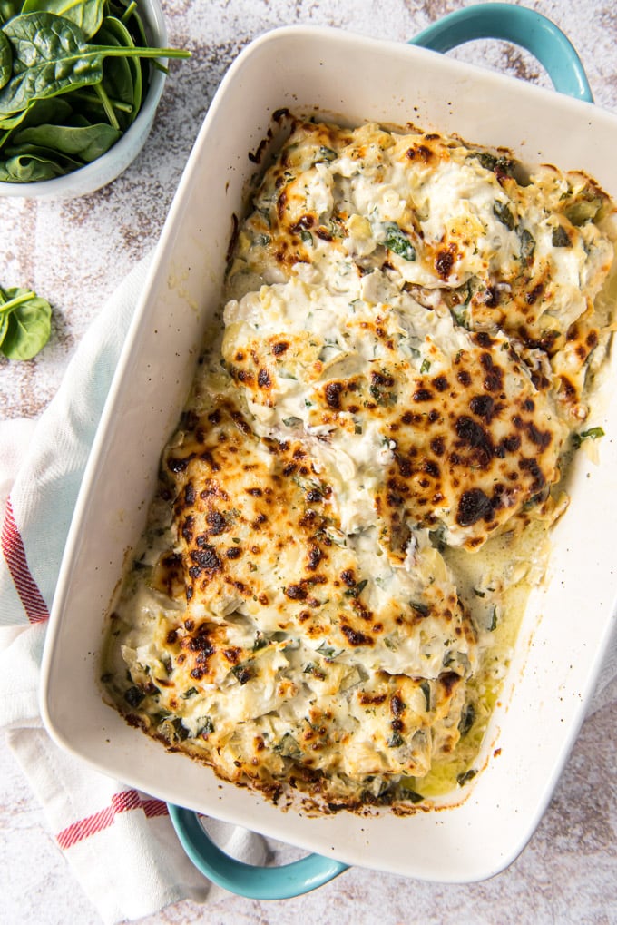 a large baking dish with chicken and toasted mozzarella on top.