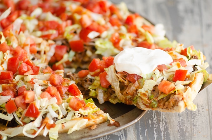 Slice of taco pizza showing the layers.