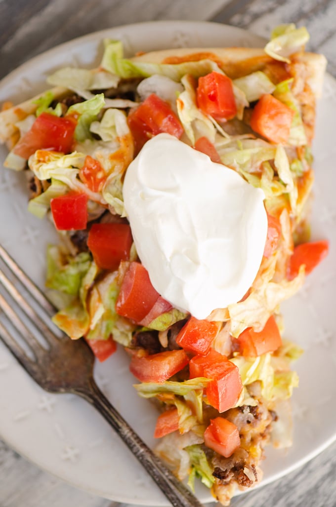 Slice of Taco Pizza with dollop of sour cream.