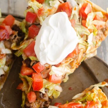 slice of taco pizza served with sour cream