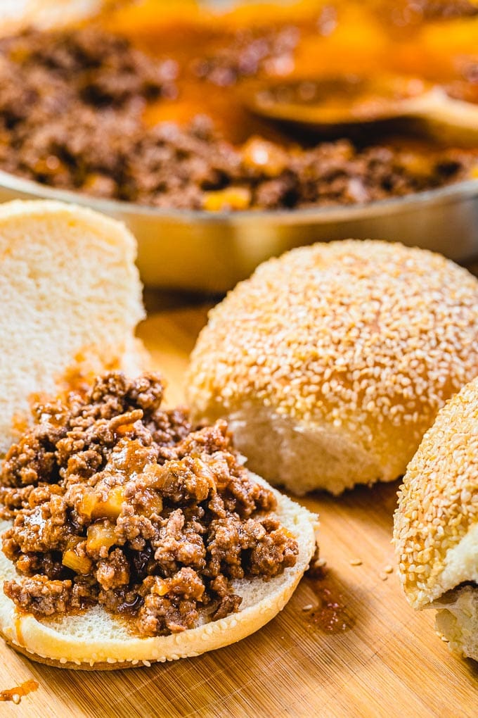 Open bun with sloppy Joe filling on cutting board.