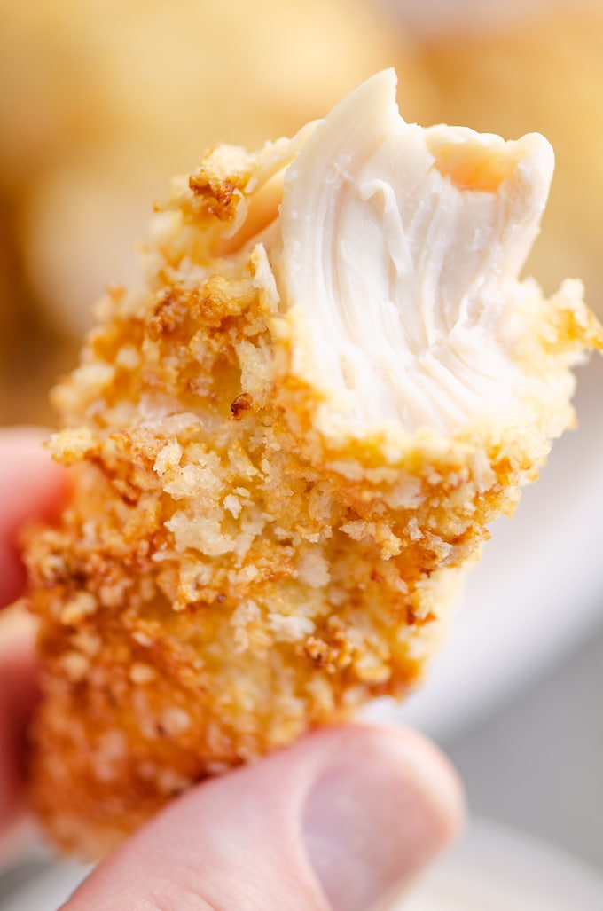 Air Fryer Chicken Tenders bit in half with juicy chicken