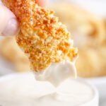 Air Fryer Chicken Tenders dipped in bowl of ranch dressing