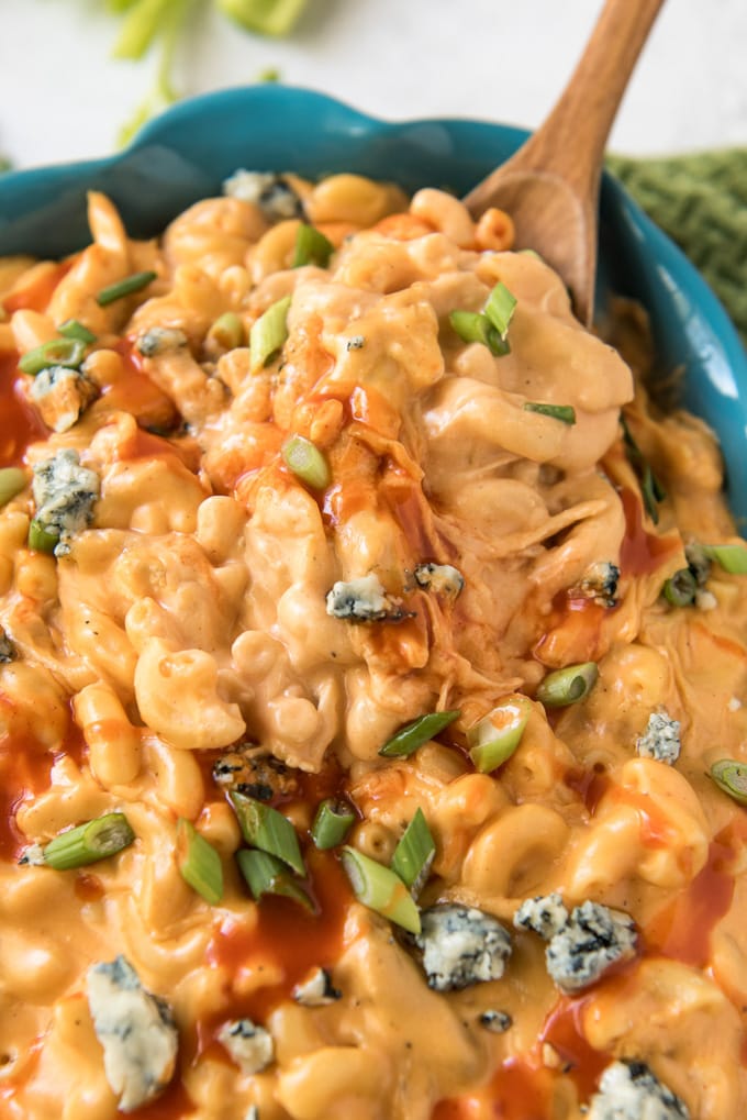 a dish filled with creamy mac and cheese with chicken and buffalo sauce