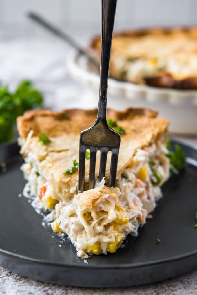 a slice of chicken pot pie with a fork in it.