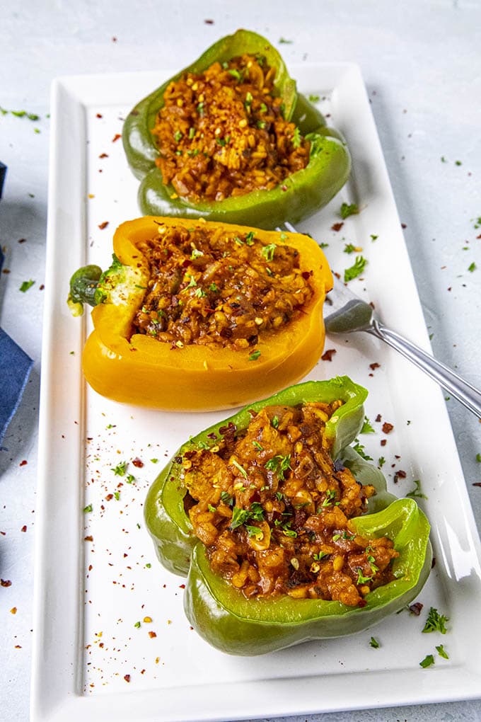 Three stuffed peppers served on a platter