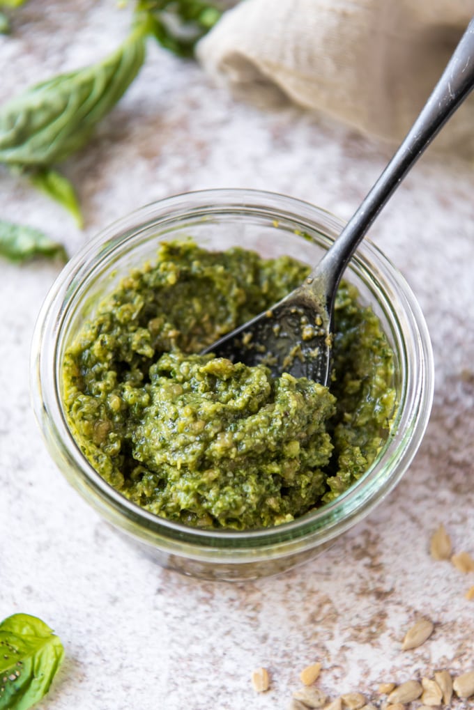 a jar of nut free pesto with a spoon in it.