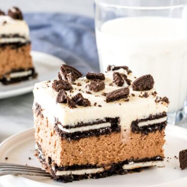 Slice of oreo icebox cake with glass of milk.