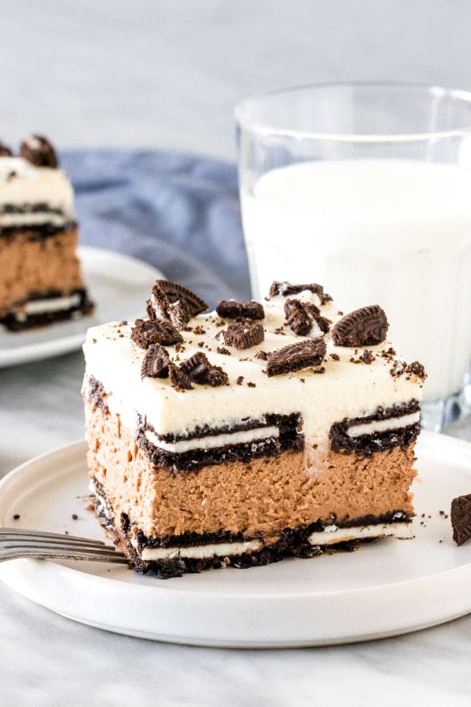 Slice of oreo icebox cake with glass of milk. 