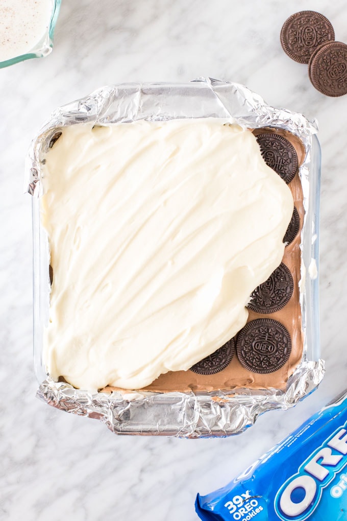 Adding the whipped cream topping to an Oreo Icebox cake.