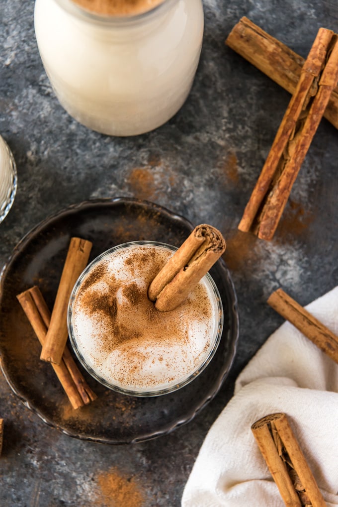 an overhead shot of a glass of horchata with a cinnamon stick in it.