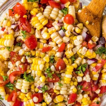 A dish full of corn salad with tomatoes