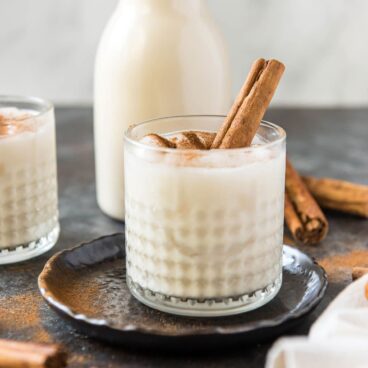 A cup of Horchata with cinnamon stick.