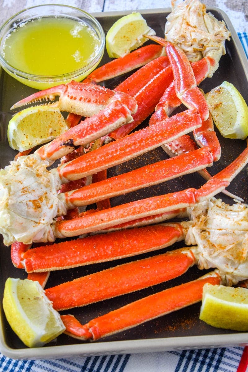 Making crab legs is easier than you think! Ready in only 5 minutes, these crab legs are the best way to treat yourself to a fancy meal at home! snow crab clusters on a plate with lemon wedges and melted butter