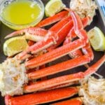Crab legs with melted butter and lemon wedges.