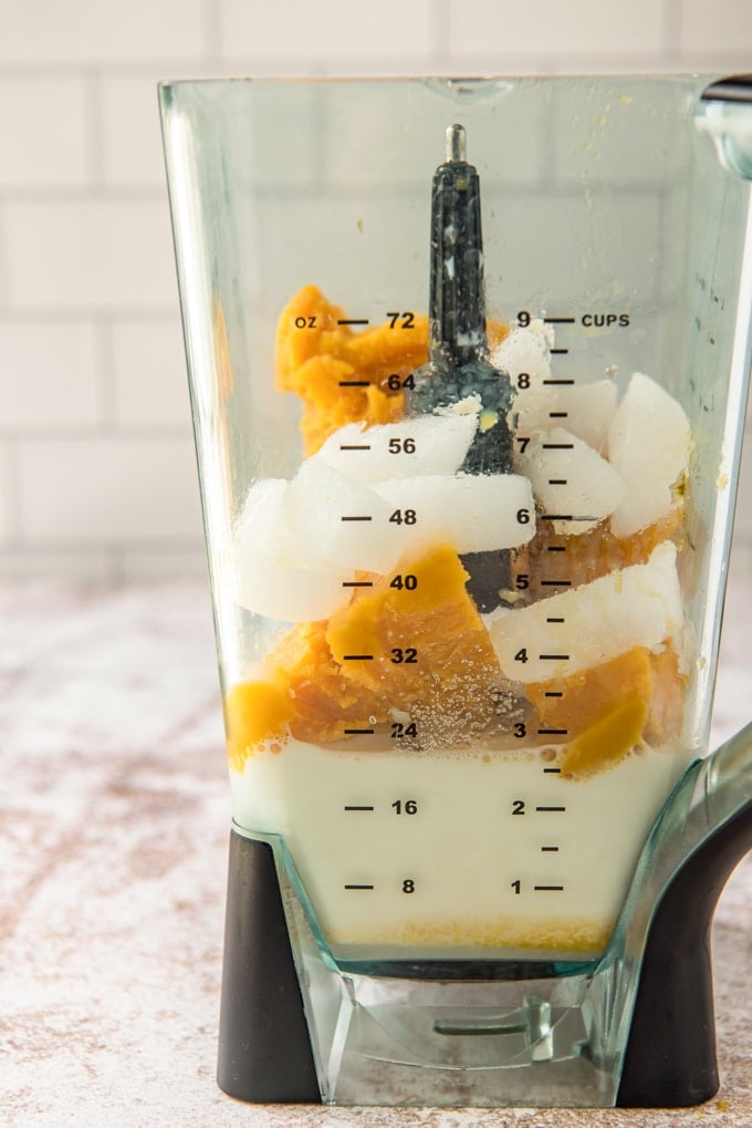 Milk, orange juice concentrate, and ice in a blender.