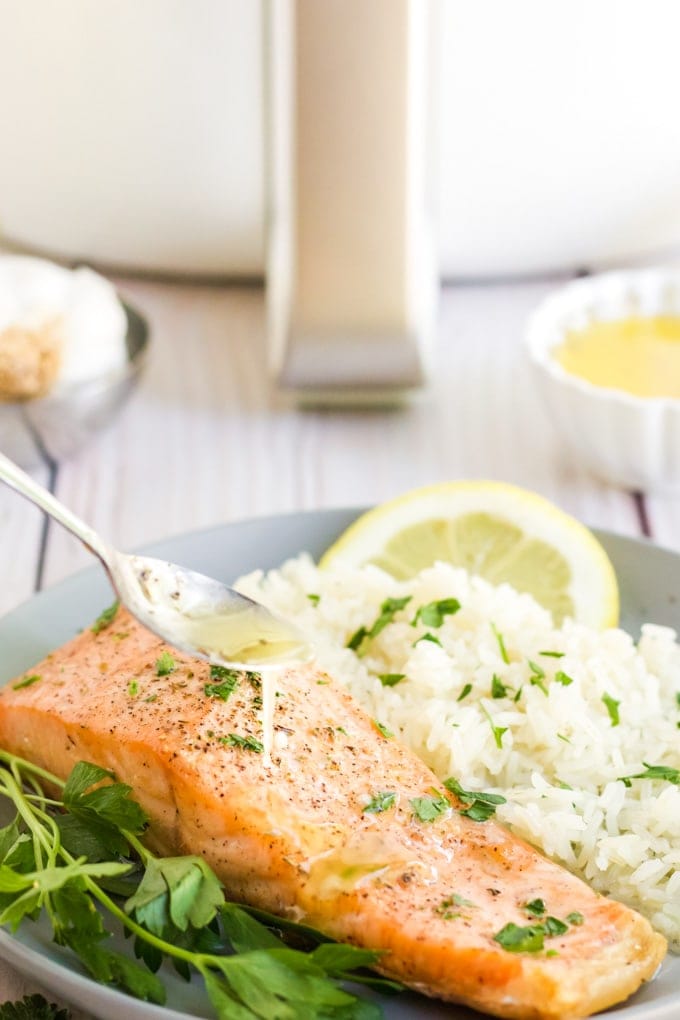 Lemon Garlic Herb Butter being spooned on to air fryer salmon