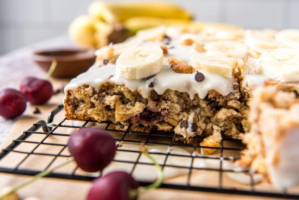 banana split bars on a wire rack, cherries, bananas and a small wooden bowl