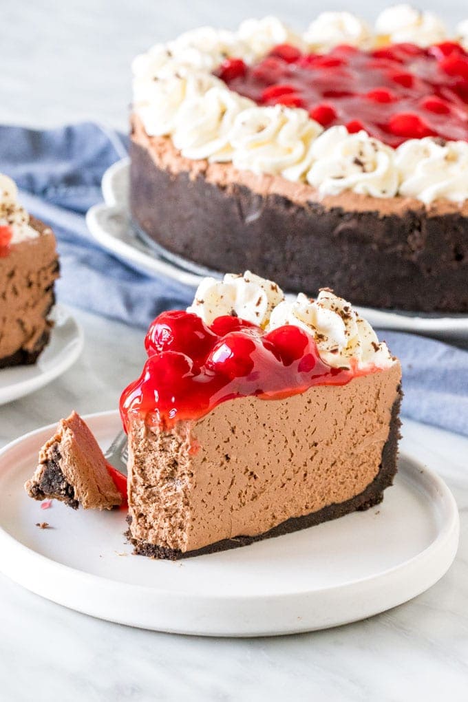 A slice of black forest cheesecake with a bite taken out of it. 