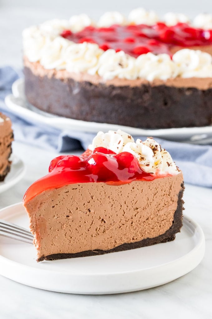 A slice of black forest cheesecake on a plate. 