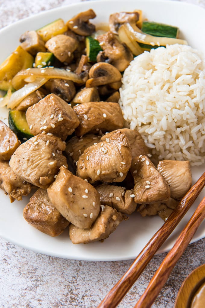 white plate, chopsticks, white rice, chicken and vegetables