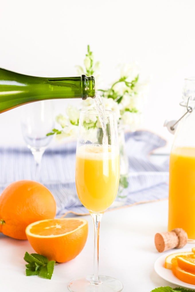 Sparkling Wine being poured into a champagne flute to make a classic mimosa. 