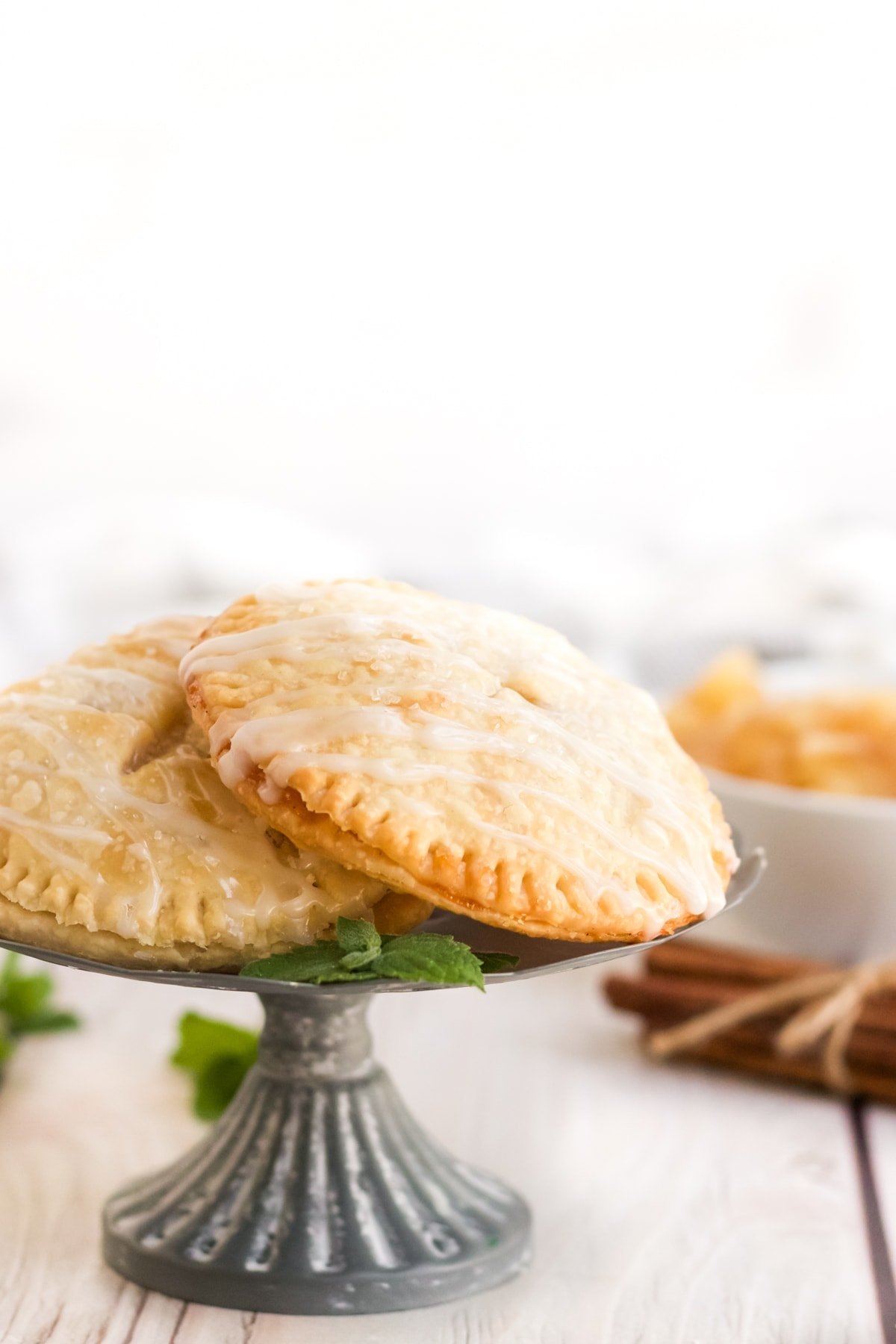 apple hand pies on silver dessert tray. cinnamon sticks,