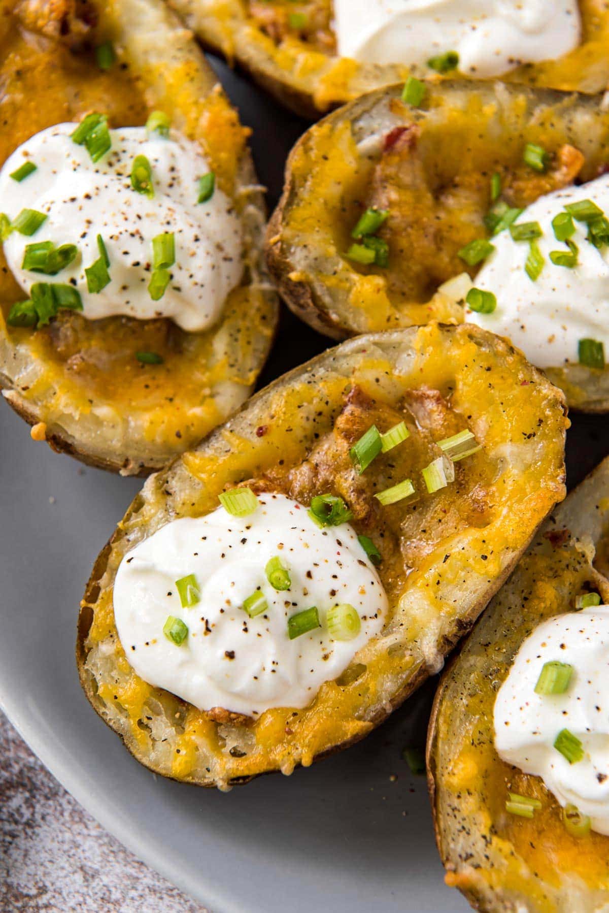 hollowed out potato skins with bacon, cheese, sour cream and chives