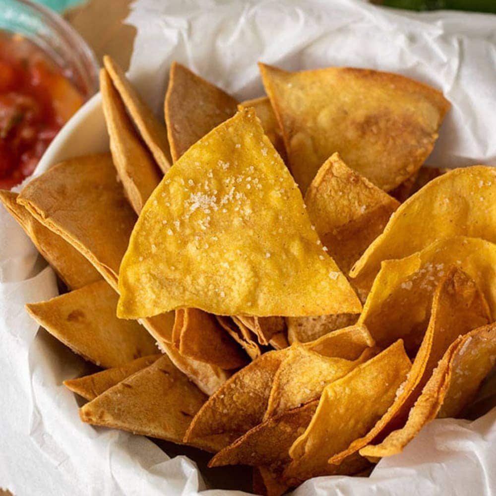 A dish filled with homemade tortilla chips sprinkled with salt.