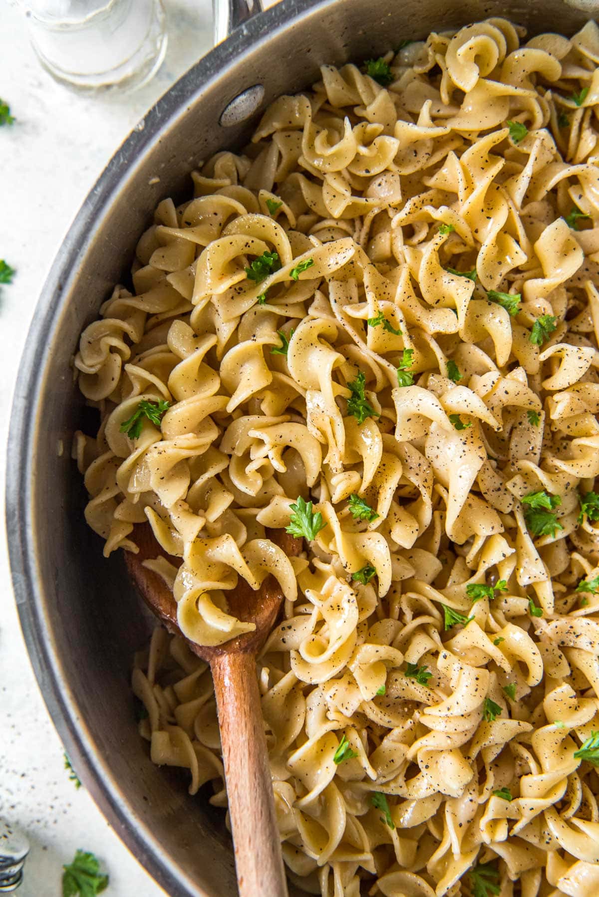 buttered noodles with parsley, wooden spoon