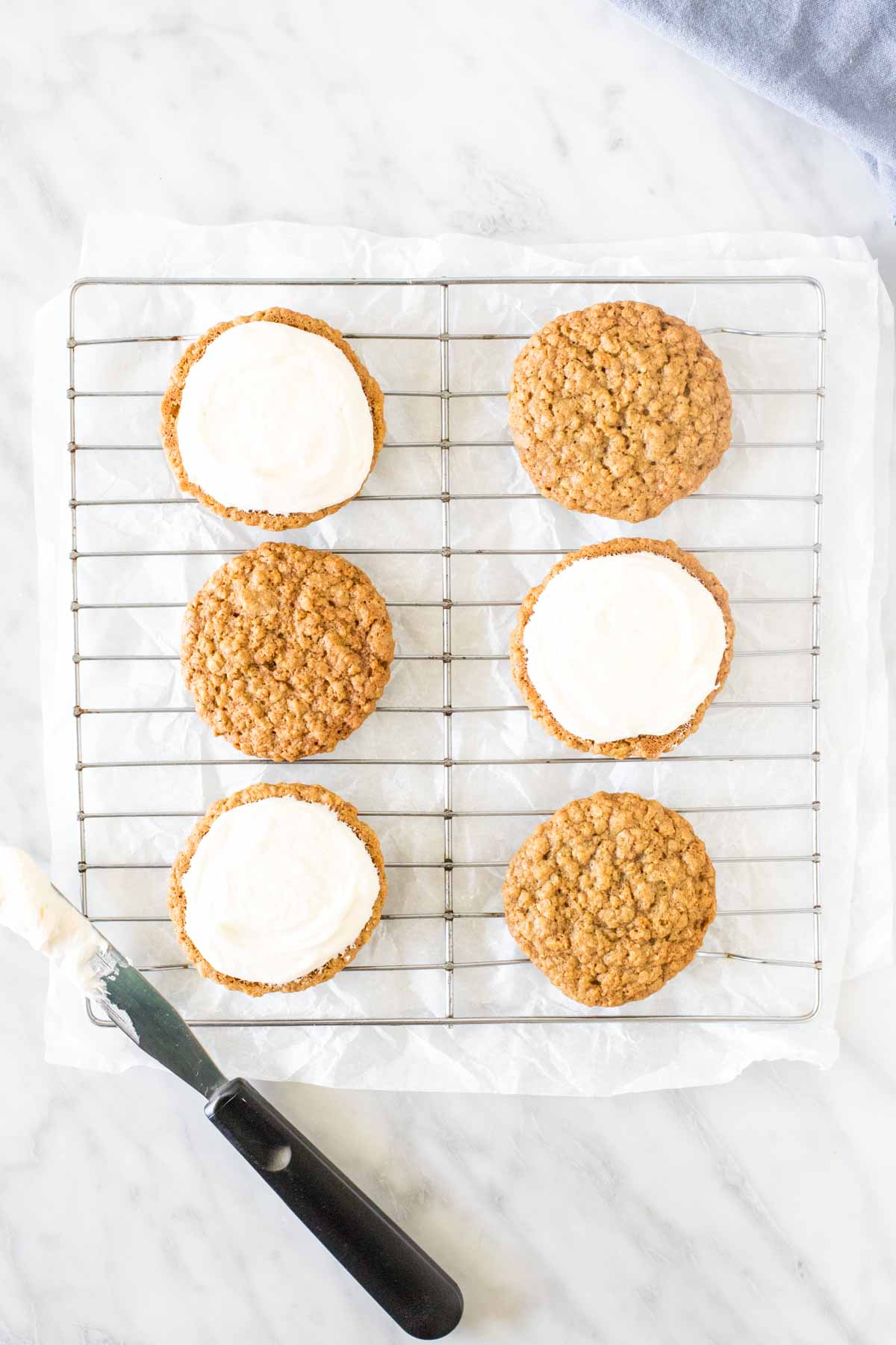 Oatmeal cookies with frosting on a wire rack. 