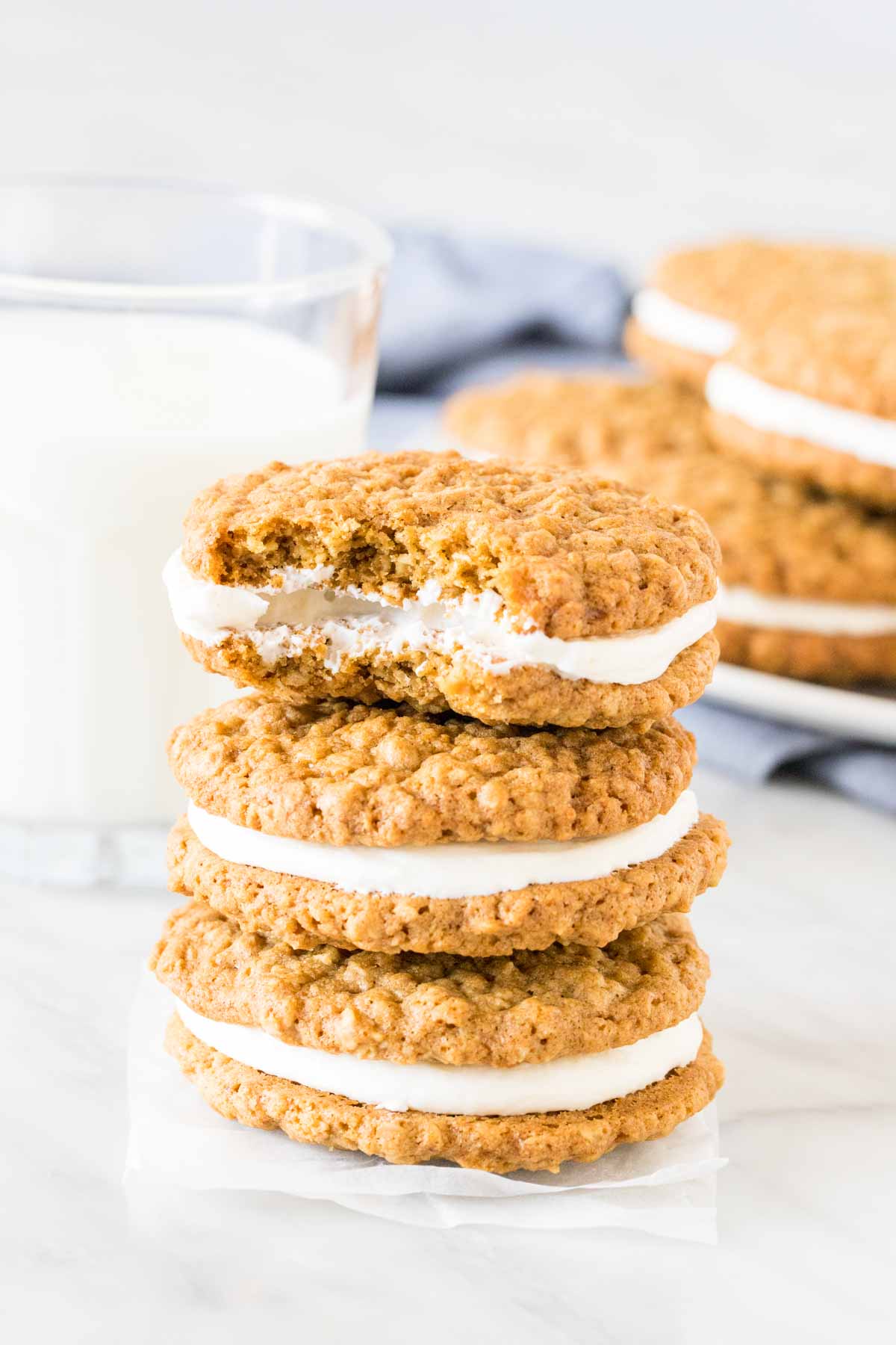 Stack of oatmeal cream pies with a bite taken out of the top cookie. 