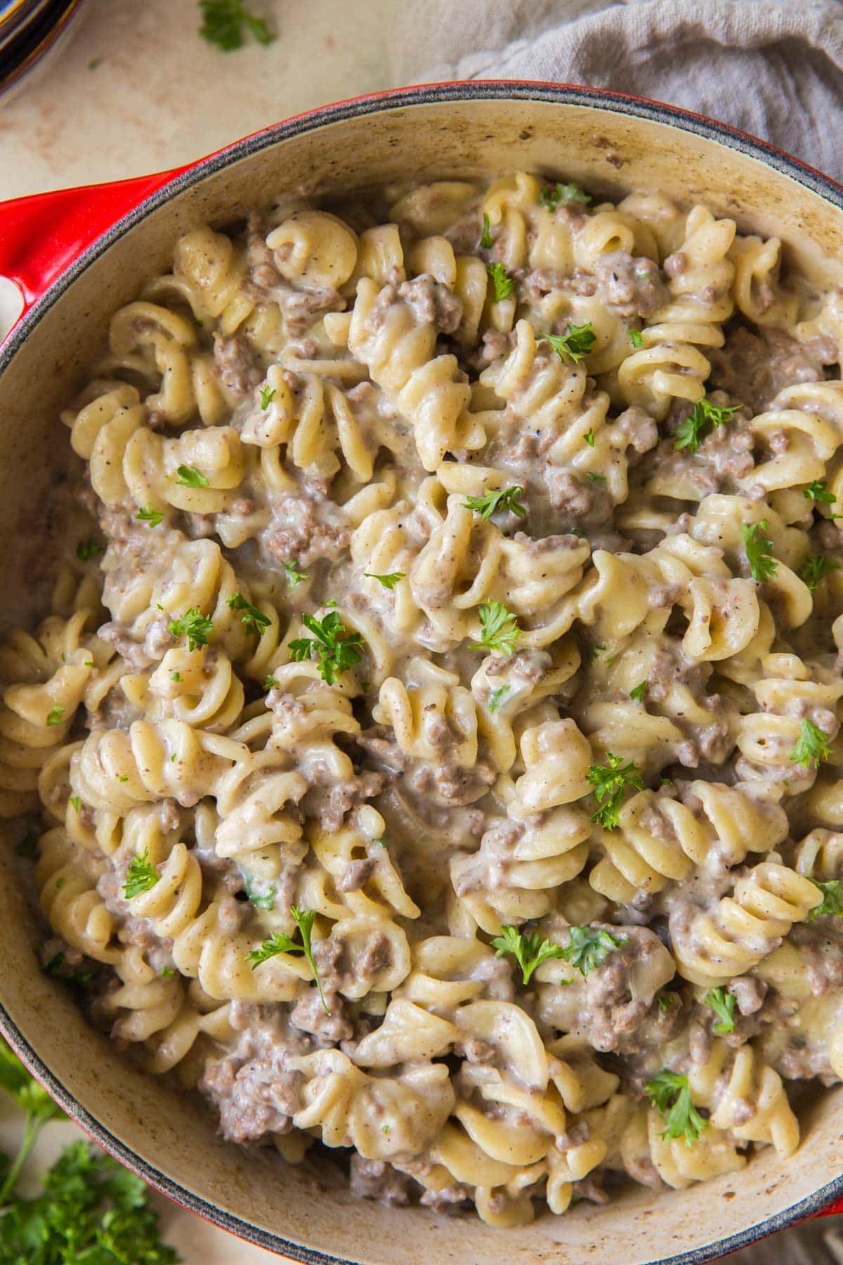 noodles, ground beef sauce and mushrooms in a red soup pot