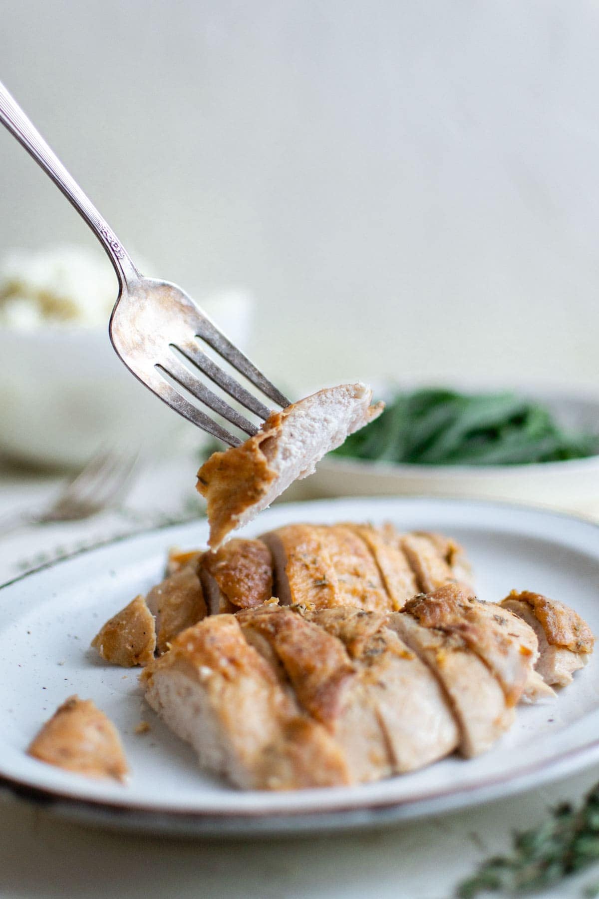 white plate with sliced turkey breast, a fork