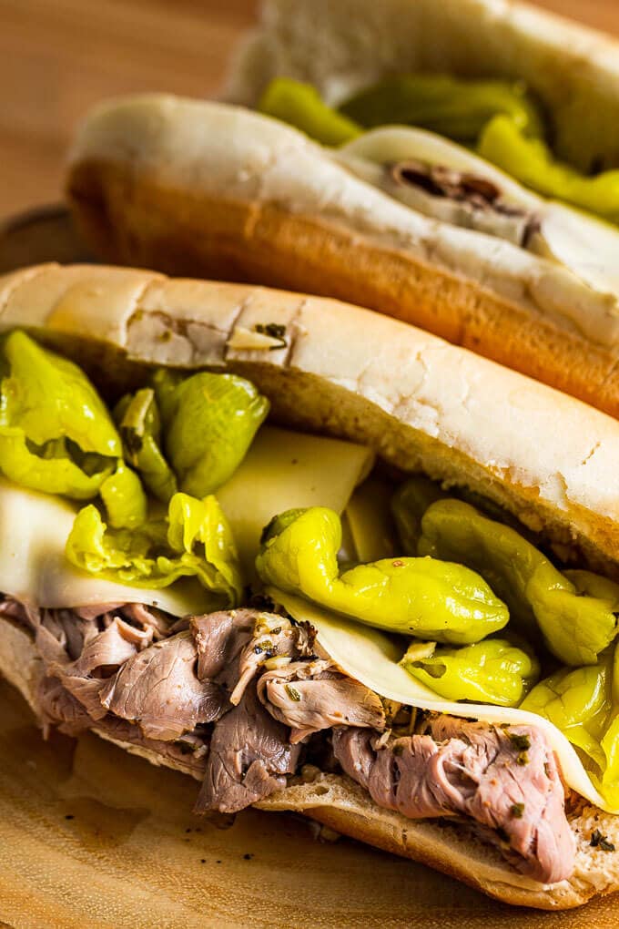 Italian beef sandwich on round wooded board.