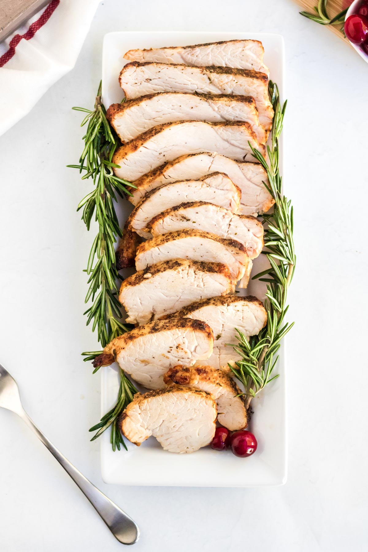 sliced turkey breast, fork, white platter