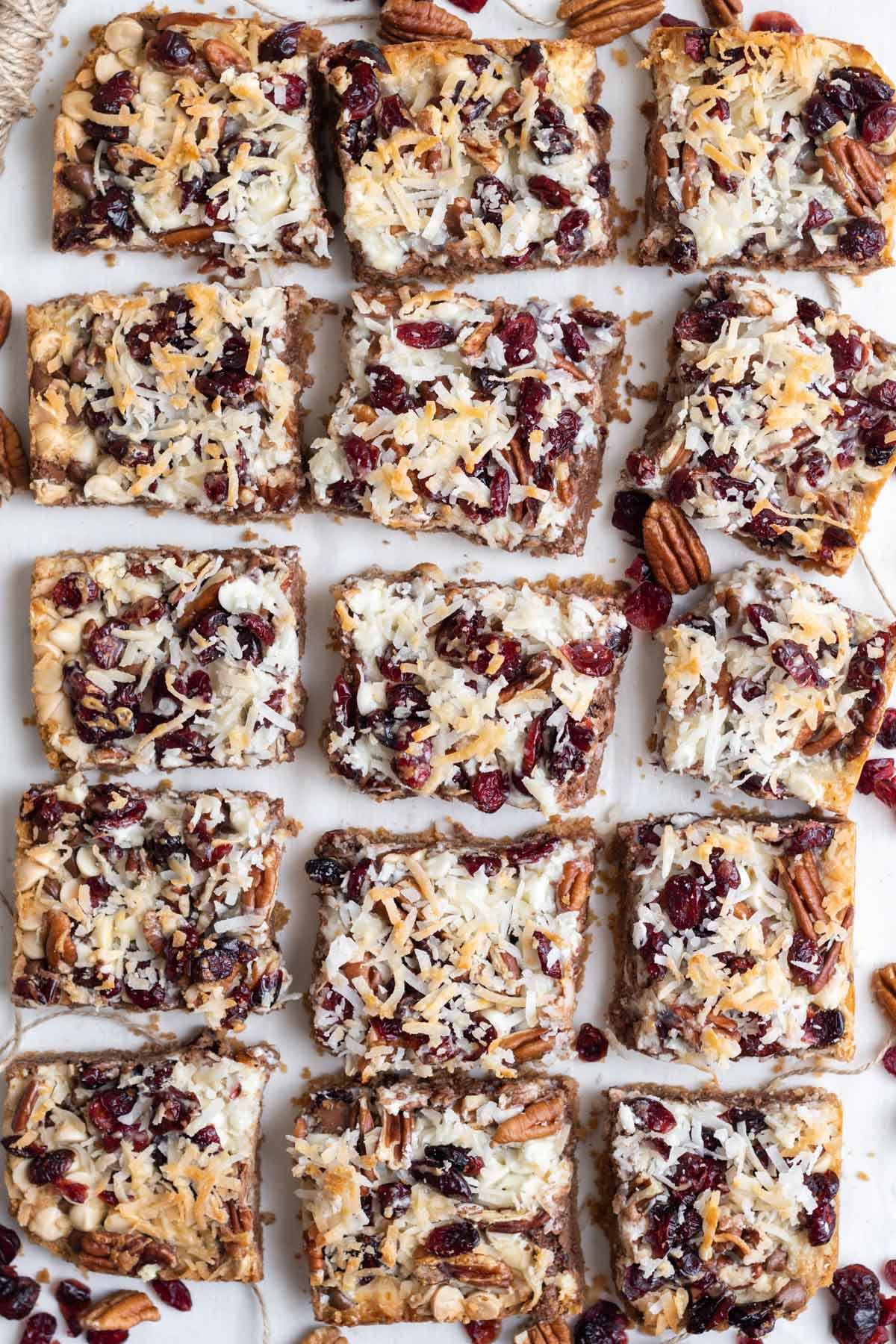 squares of cranberry magic bars on white background