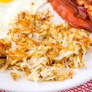 square image of hash browns with eggs and bacon