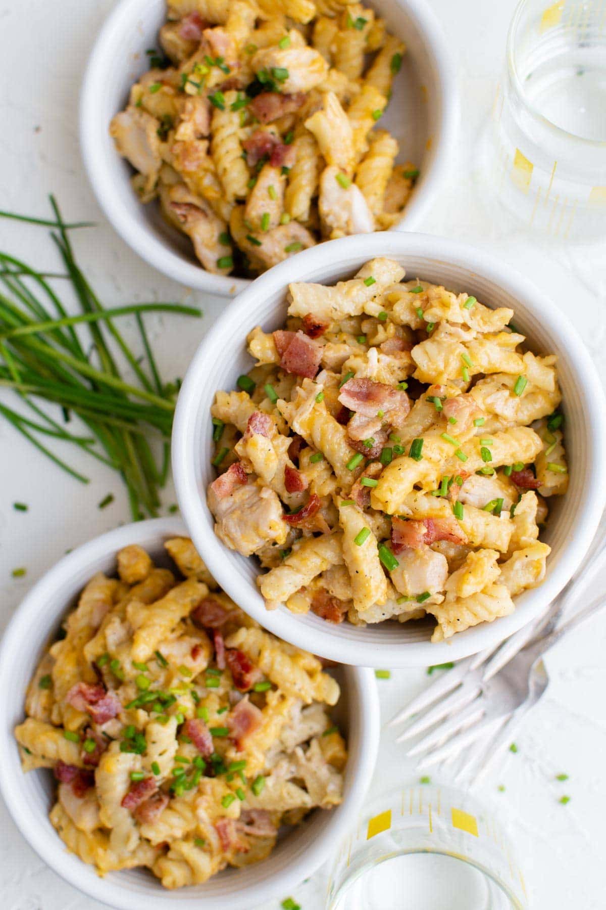 three white bowls, cheese, bacon, chicken pasta, chives