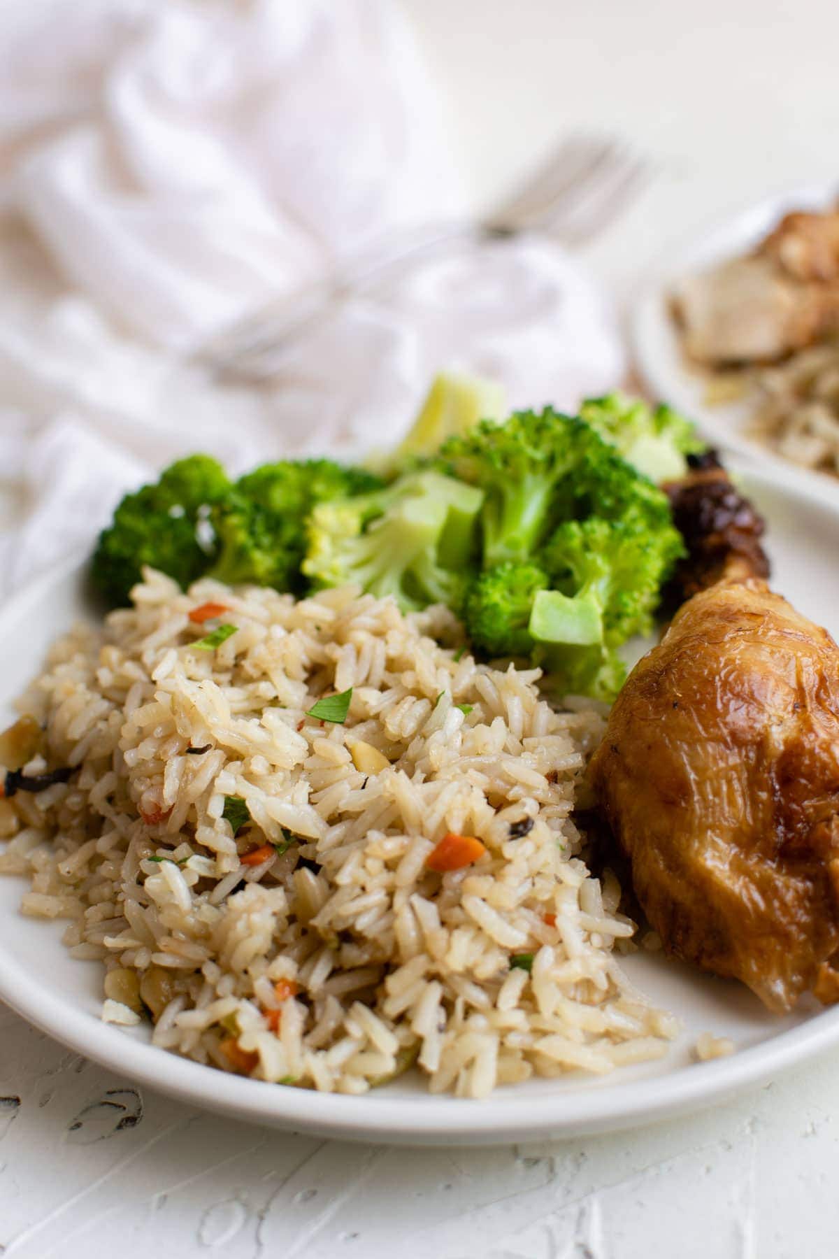 white plate with chicken, broccoli and rice pilaf