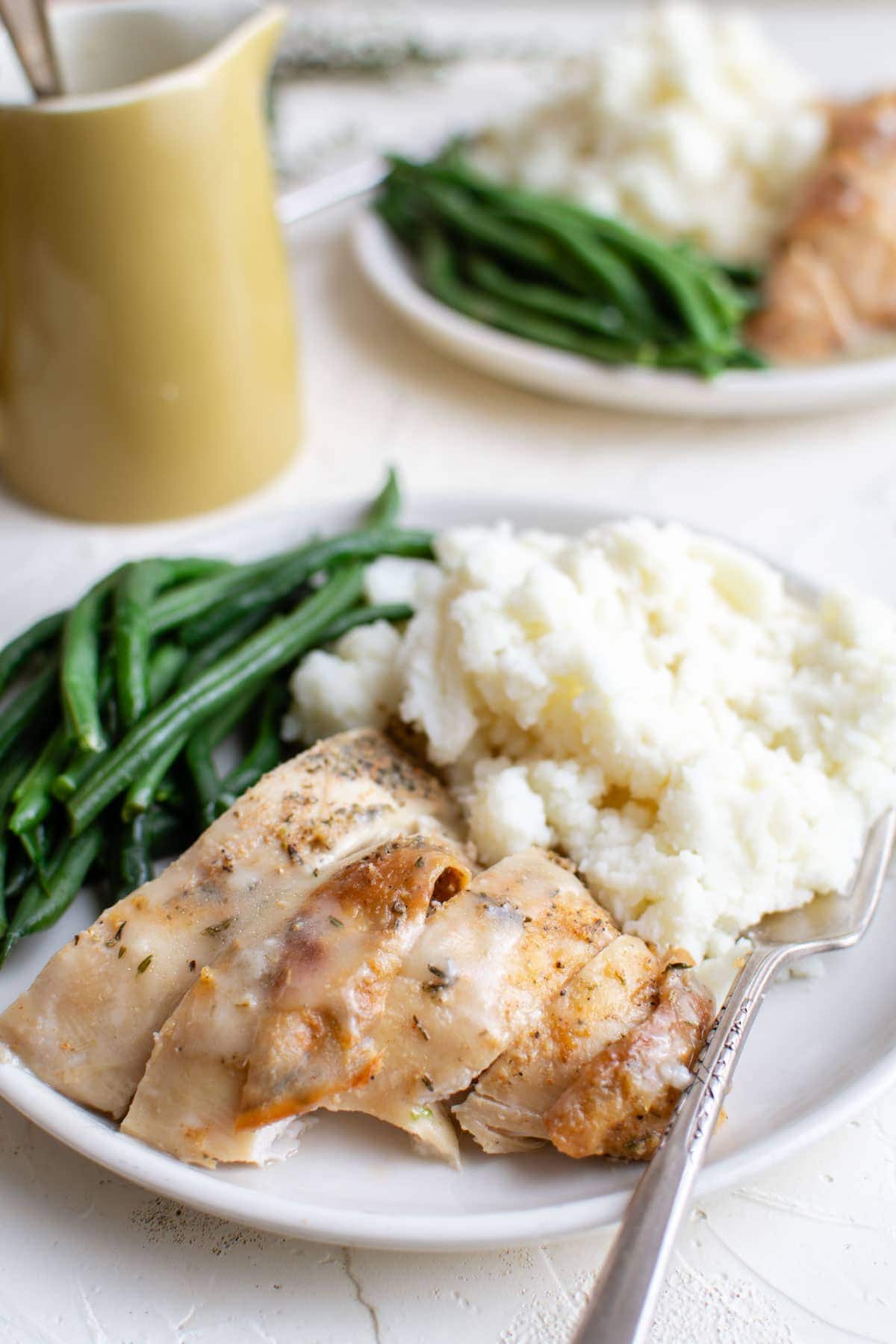 white plates with green beans, turkey, mashed potatoes and gravy