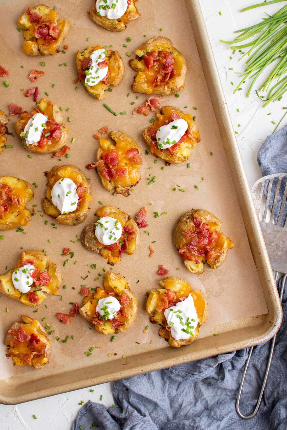sheet pan with smashed potatoes, bacon cheese and sour cream