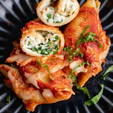 stuffed shells with cheese and basil, black plate