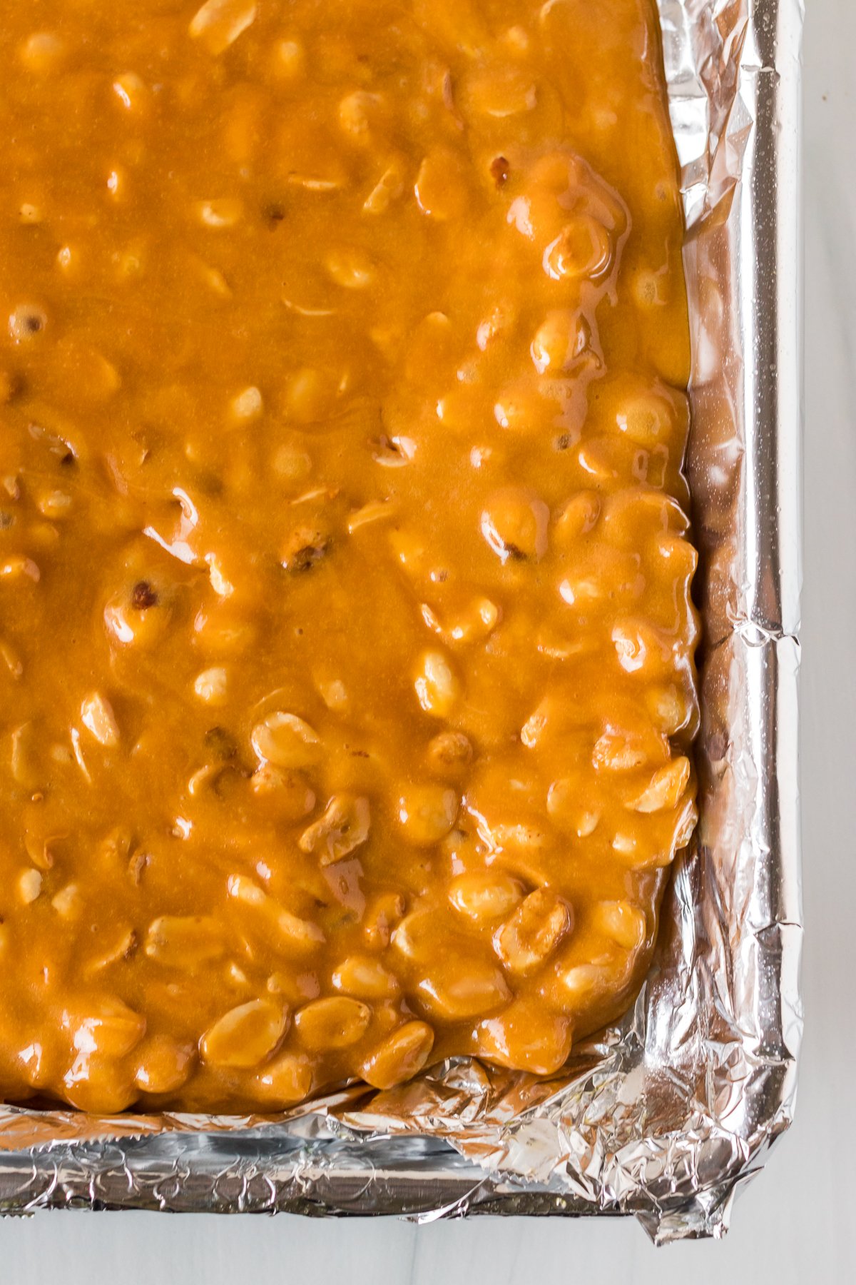 overhead shot of peanut brittle on baking sheet