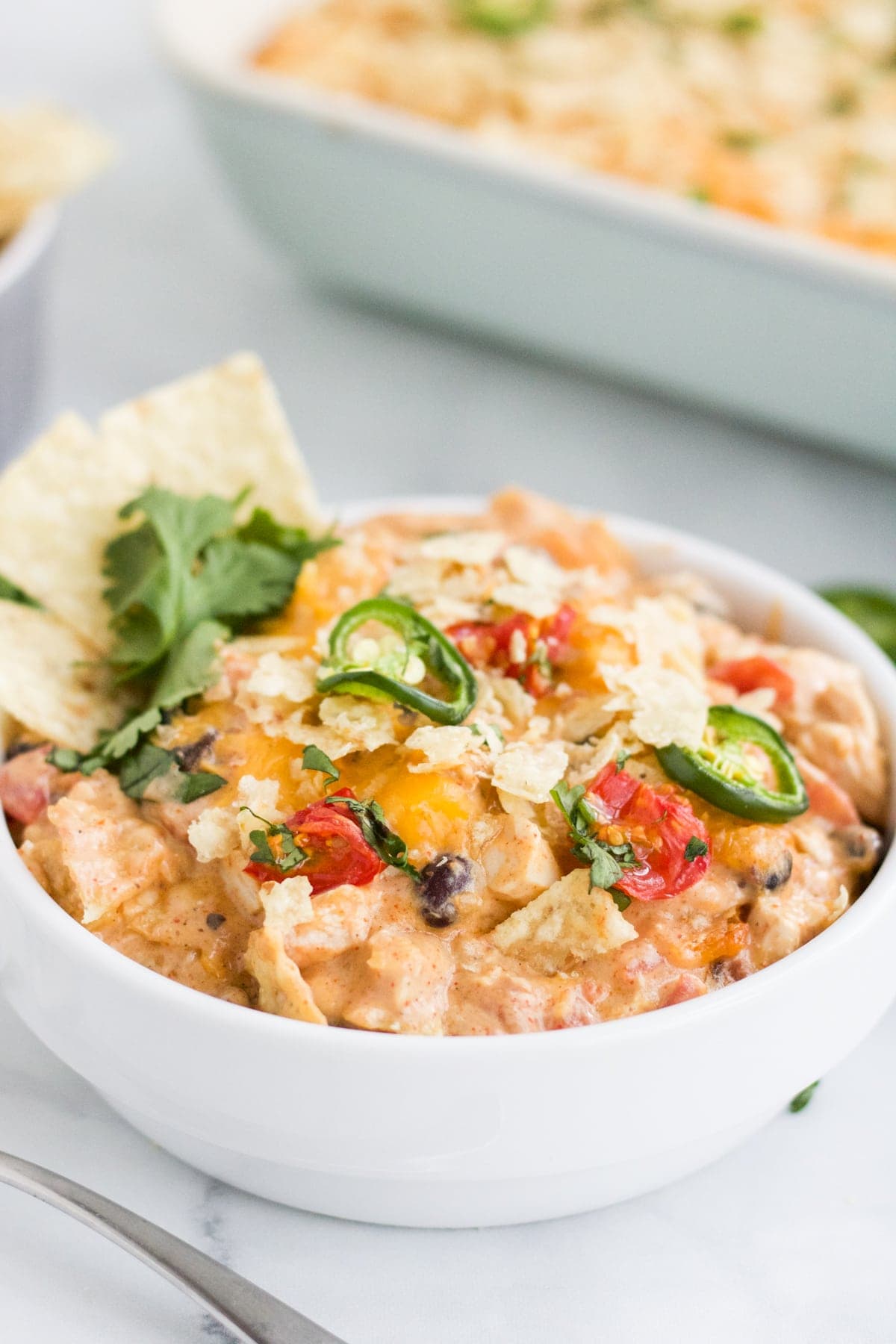 Chicken taco casserole in a small white casserole dish. 