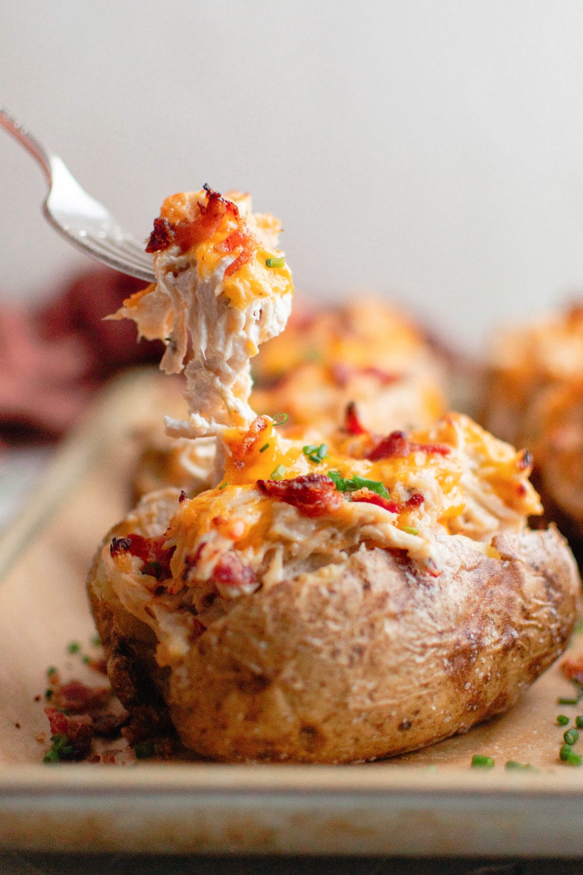 stuffed baked potato with chicken and cheese, fork, baking sheet